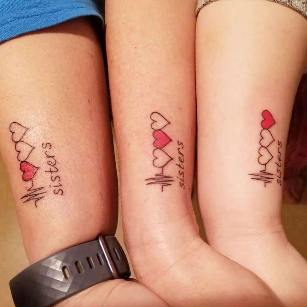 Matching sister tattoos featuring connected hearts in a row with a heartbeat line and the word 'sisters'