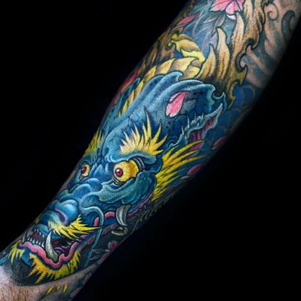 Colorful dragon tattoo on a forearm with blue, yellow, and pink details