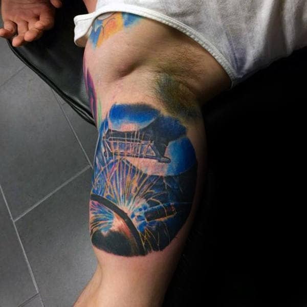 Blue Ink Guys Welding Bicep Tattoo With Flying Sparks Design