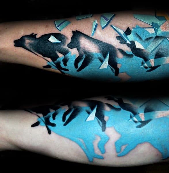 Arm tattoo of wolves breaking through blue shattered glass