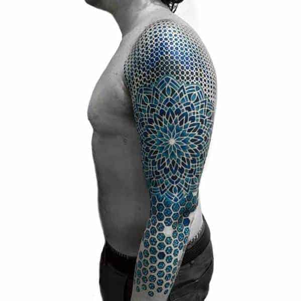 Man with geometric sleeve tattoo in black and blue ink on his right arm and shoulder
