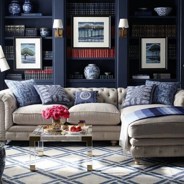 Elegant living room with a beige sofa, blue accents, and a stylish bookshelf of framed art