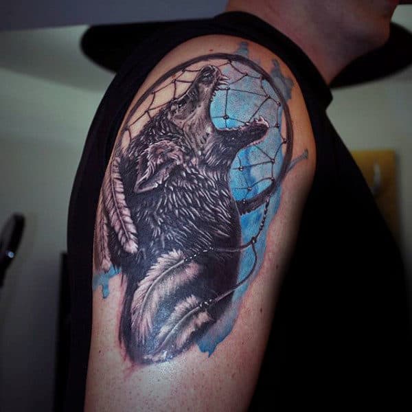 Blue Watercolor Ink Dreamcatcher Upper Arm Tattoo With Howling Wolf And White Feathers