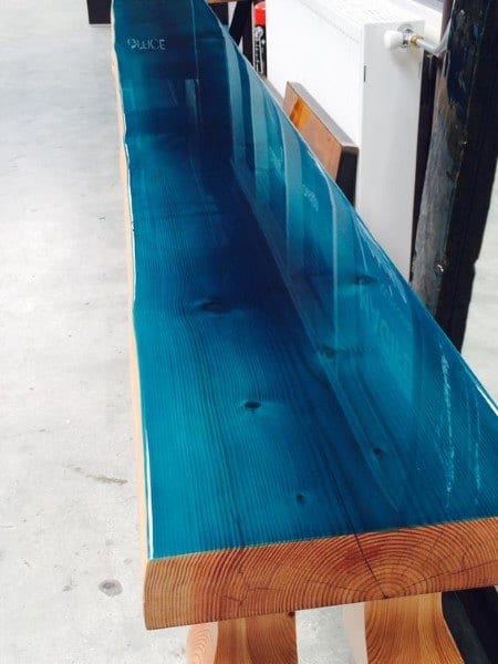 Stylish bar top featuring a rich wooden base with a vibrant blue epoxy resin finish, showcasing a sleek design.