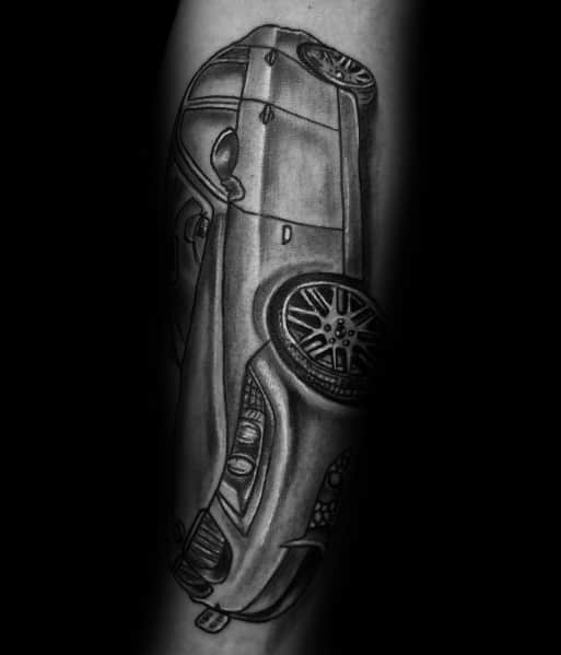 Realistic BMW tattoo on forearm, featuring a dynamic top-down perspective with bold shading for a striking automotive design.