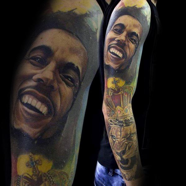 Full sleeve color tattoo of Bob Marley smiling, with a regal lion wearing a crown below, blending realism with Rastafarian symbolism.