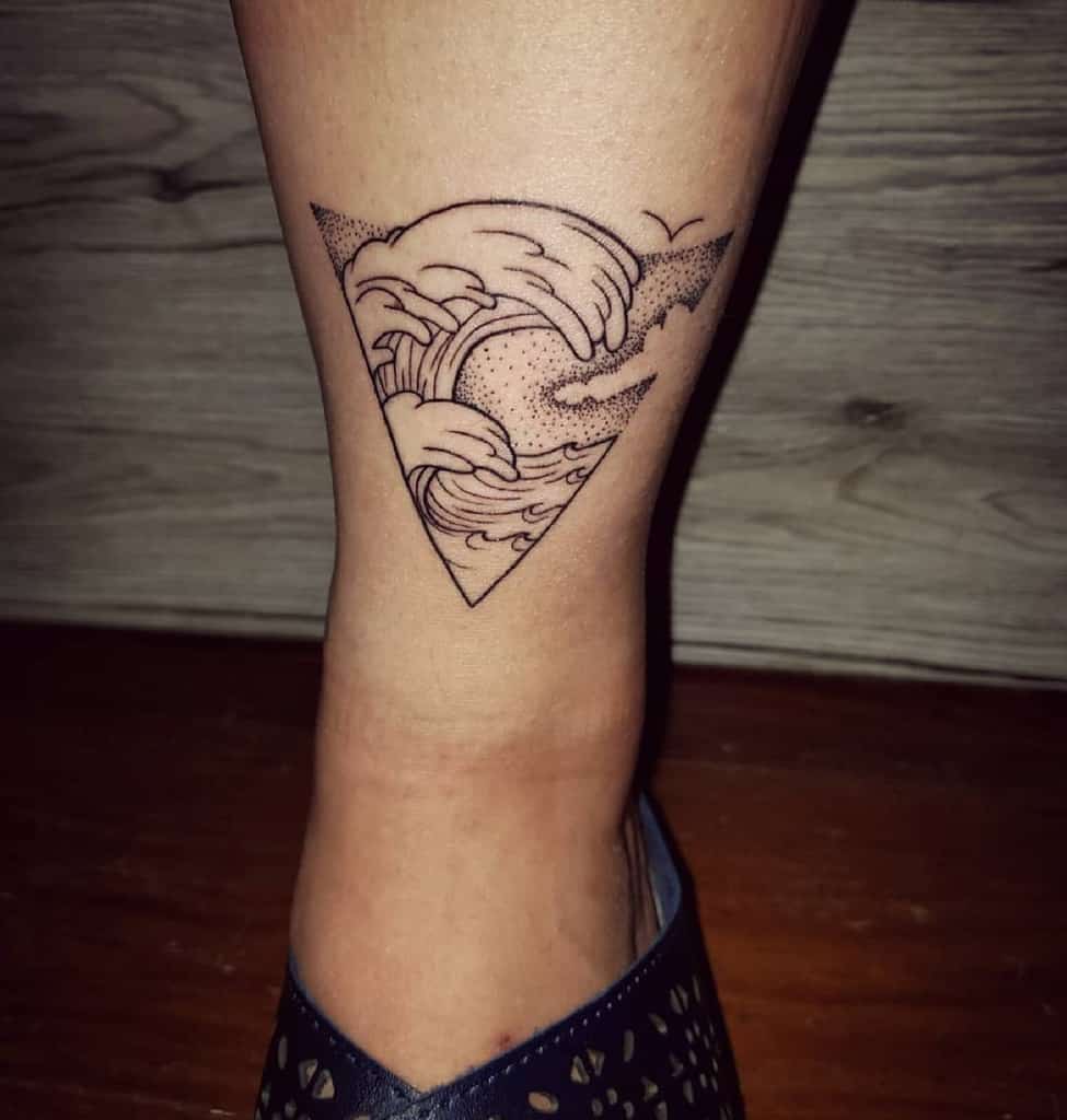 Minimalist tattoo featuring ocean waves forming a heart shape within a triangle, with fine line details and dot shading