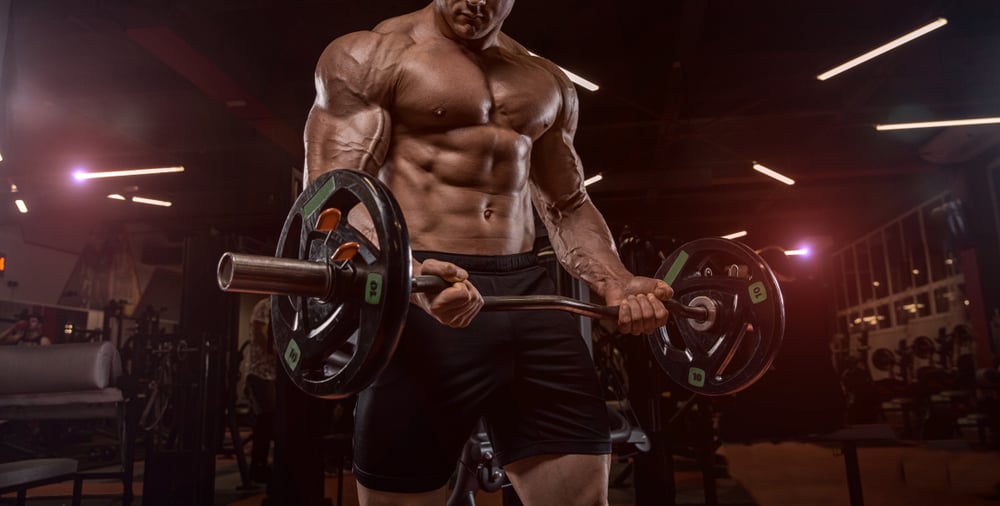 bodybuilder in the gym doing the exercise with dumbbells