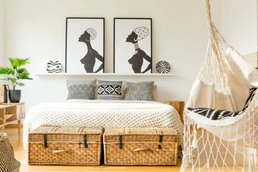 African-inspired bedroom with hammock, wicker storage, and black-and-white wall art.