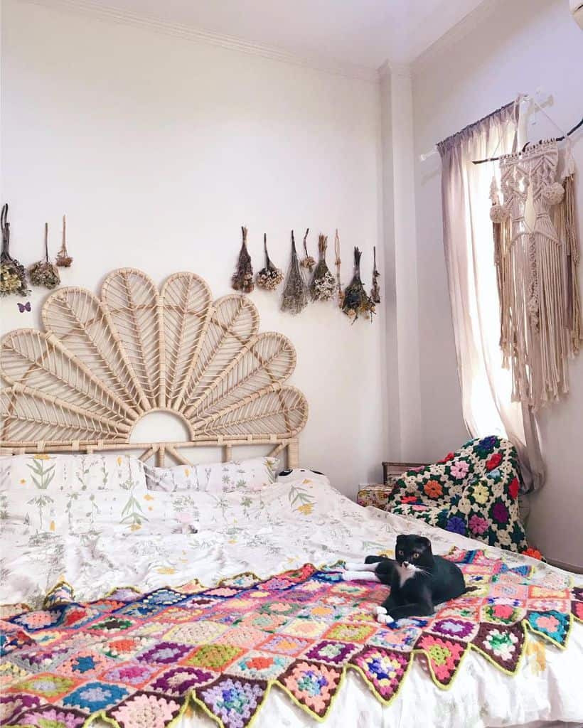 Boho bedroom with wicker headboard, botanical bedding, and colorful crochet throw.