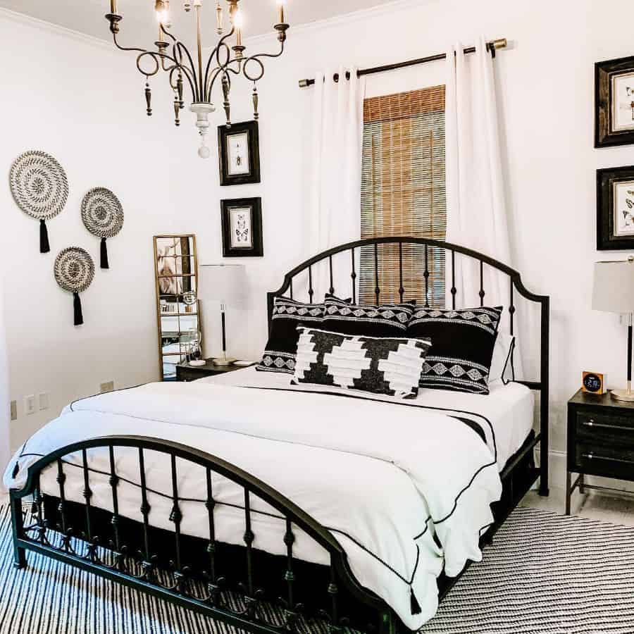 Boho bedroom with black metal bed frame, patterned pillows, and woven wall decor.