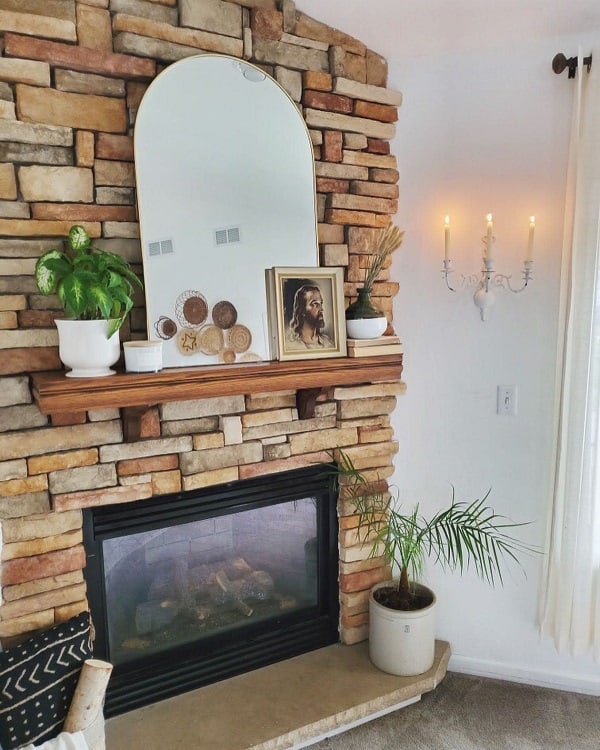stone fireplace with mirror on mantel