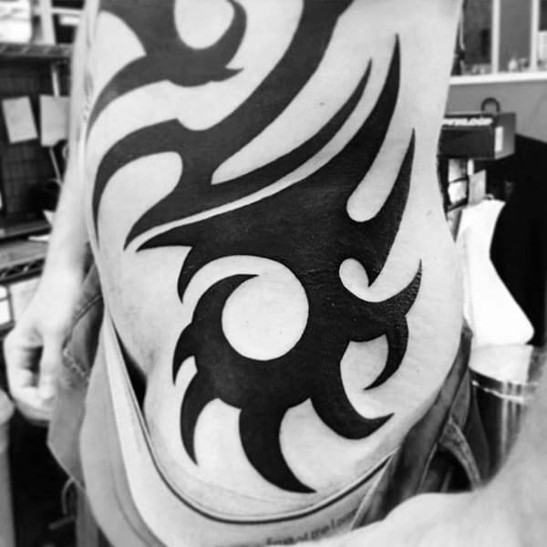 Bold Black Ink Mens Large Tribal Rib And Hip Tattoos
