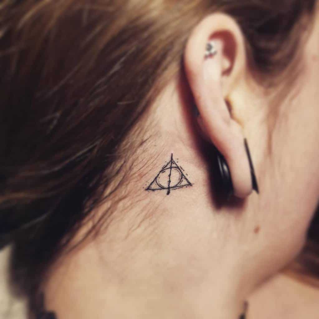 Minimalist Deathly Hallows tattoo featuring a delicate, sketch-style design symbolizing the Elder Wand, Stone, and Cloak