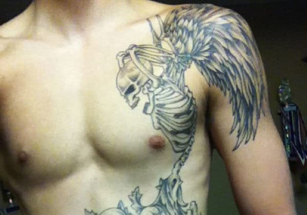 A detailed skeletal wing tattoo on a person's left shoulder and chest