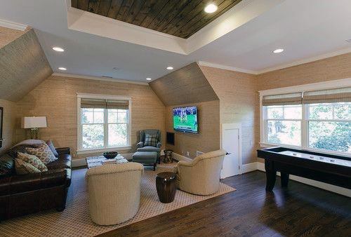 Cozy family room with armchairs, leather sofa, wall-mounted TV, and shuffleboard table.