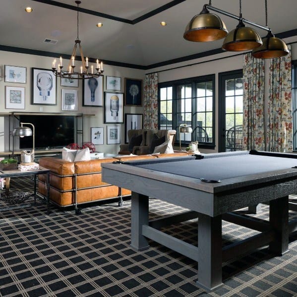Elegant game room with pool table, leather sofa, and framed wall art.