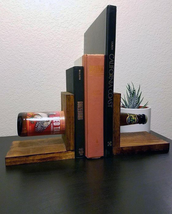 Bookends holding three books with beer bottles, one bottle embedded in a plant pot