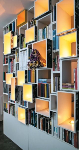 Modern bookshelf with books and lit cubby spaces creating a warm, cozy atmosphere