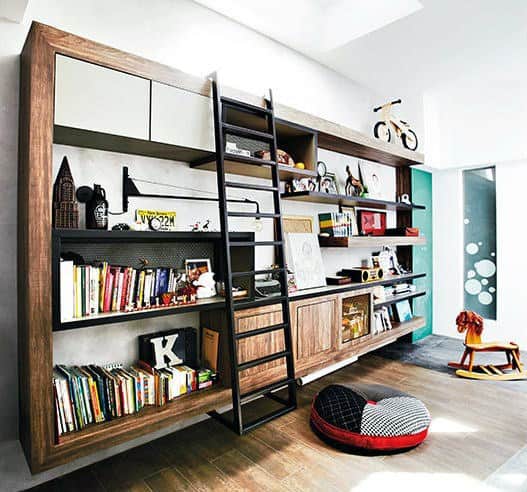 Modern living room with a large bookshelf, ladder, books, decorative items, and a small rocking horse