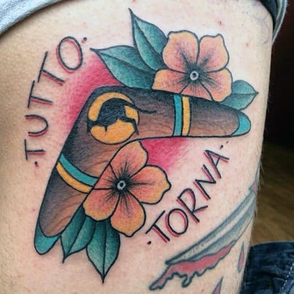 Colorful boomerang tattoo with flowers and leaves, featuring the Italian phrase TUTTO TORNA in bold lettering around it.