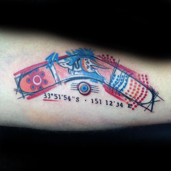Abstract boomerang tattoo with bold red and blue details, featuring coordinates 33°51′54″S 151°12′34″E below the design.