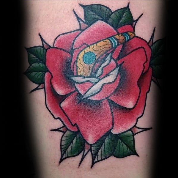 Traditional rose tattoo with a detailed boomerang nestled in the center, blending bold reds, greens, and warm brown tones.