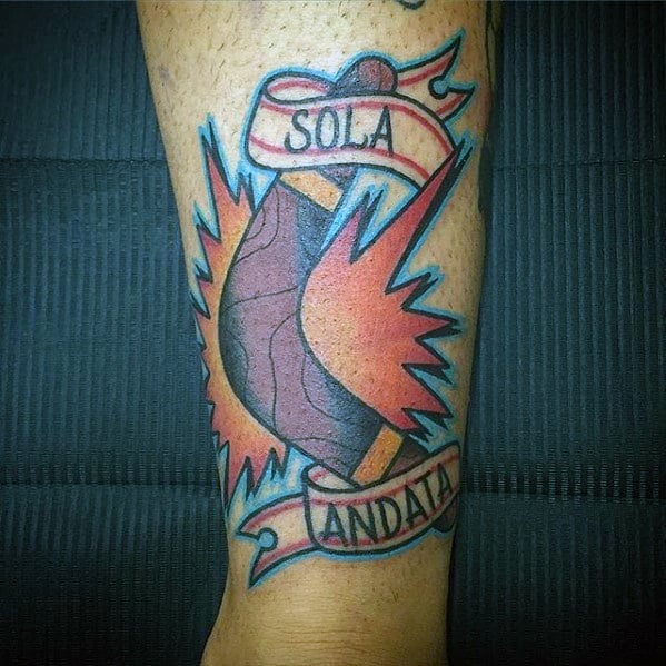 Boomerang tattoo with a bold red and blue burst, wrapped in a ribbon that reads SOLA ANDATA, meaning one way in Italian.