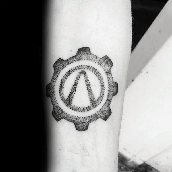 Dotwork Borderlands logo tattoo enclosed in a gear shape, done in black ink for a mechanical, industrial feel.
