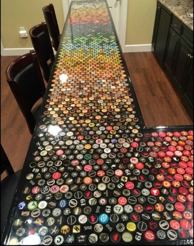Colorful bar top adorned with an array of bottle caps, beautifully encased in epoxy resin for a unique finish.