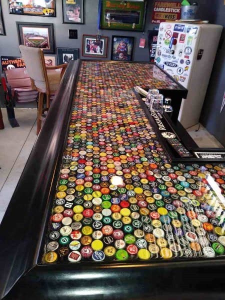 Vibrant bar top featuring an array of colorful bottle caps, encased in glossy epoxy for a playful look.