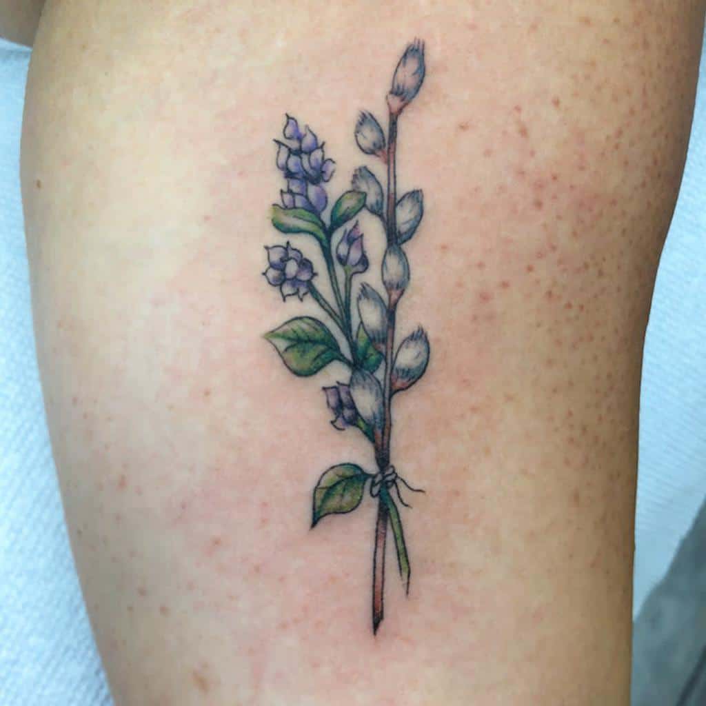 Delicate tattoo of a lilac and pussy willow branch tied together, featuring fine-line details and soft watercolor shading.