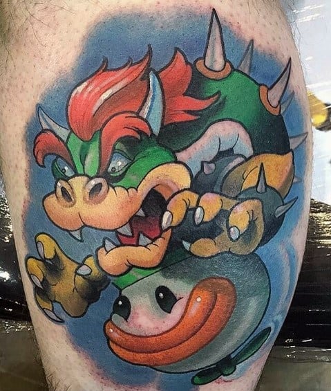 Vibrant Bowser tattoo on a man's leg featuring bold colors, dynamic shading, and a fierce pose with the signature Clown Car from Mario games.