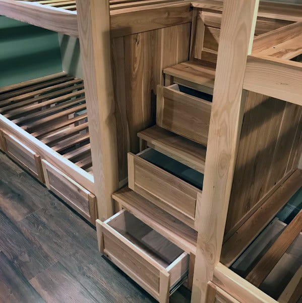 Wooden bunk bed with built-in drawers and storage stairs.