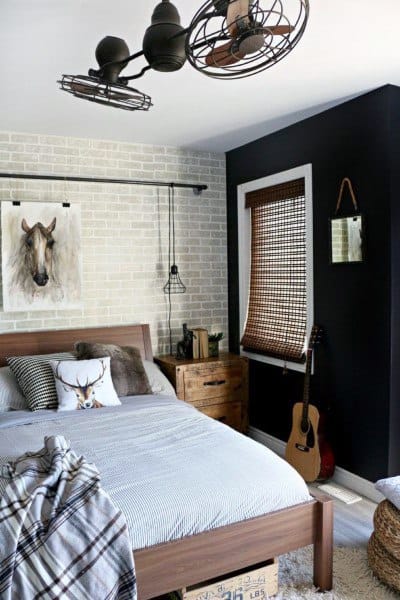 Cozy bedroom with rustic decor, featuring a bed, horse artwork, guitar, and modern ceiling fan