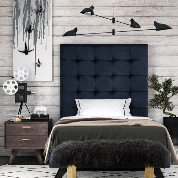 Stylish bedroom with a dark tufted headboard, modern art, and unique lighting fixtures