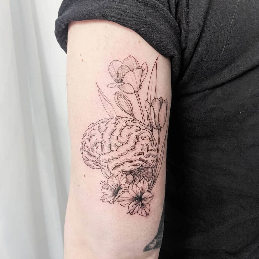 A creative tattoo combining a detailed brain with tulips and other flowers, blending the human mind and nature in a delicate design.