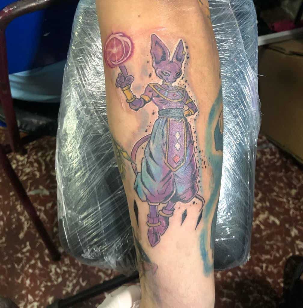 A tattoo of Beerus from Dragon Ball, standing with a staff and a purple color scheme, exuding a cosmic aura.