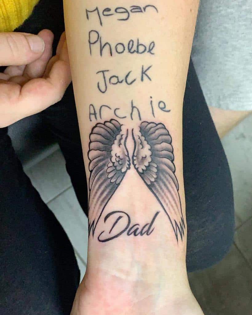 Tattoo of angel wings with "Dad" below and names "Megan, Phoebe, Jack, Archie" written above the wings