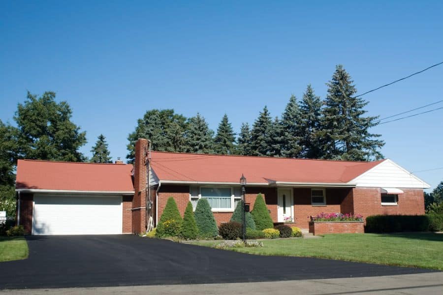 large brick ranch-style house with garage