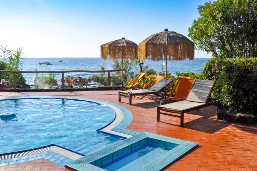 tropical brick pool patio with sun loungers