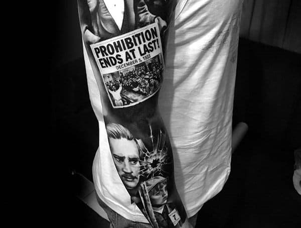 Black and grey realism tattoo sleeve featuring prohibition-era imagery, including a newspaper headline, portraits, and a shattered glass effect.