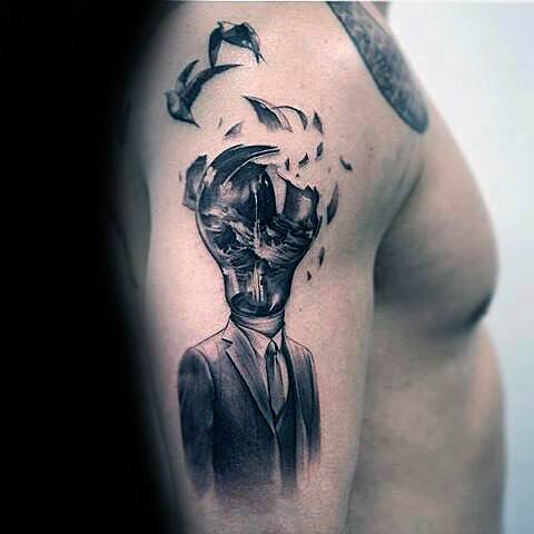 Surreal tattoo of a faceless man in a suit with his head exploding into shards of glass and birds, symbolizing chaos or release.