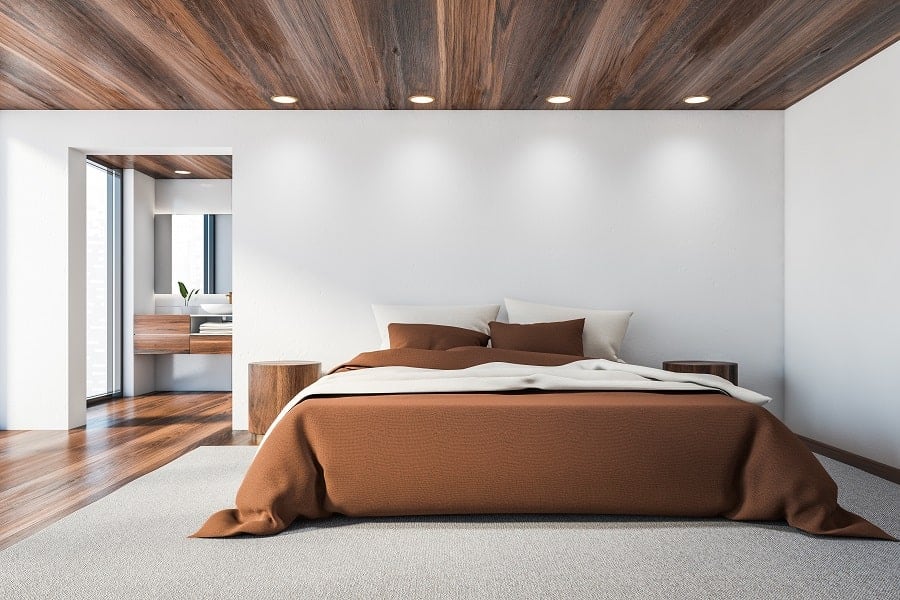 minimalist modern bedroom with white walls and wood flooring and ceilings 