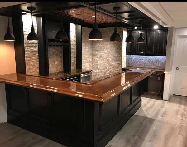 Stylish bar featuring a rich brown epoxy top, black cabinetry, and modern pendant lighting.