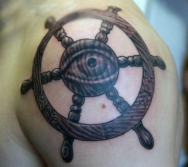 Brown Ink Ship Wheel With Eye Tattoo On Shoulder For Men