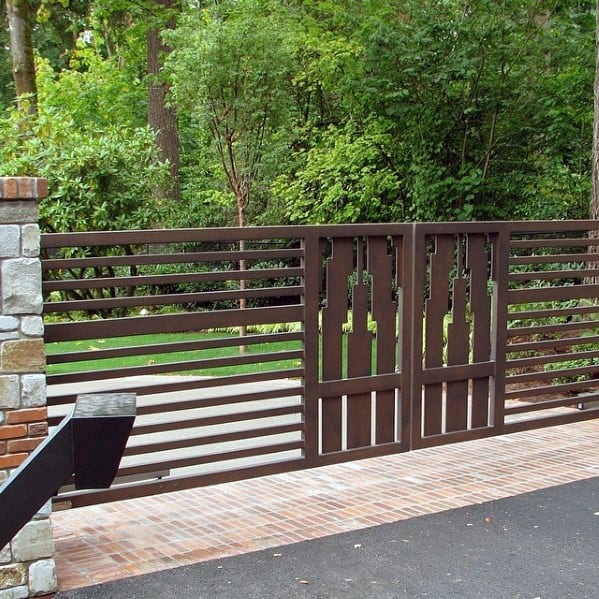 Brown steel driveway gate with horizontal slats and decorative geometric patterns.