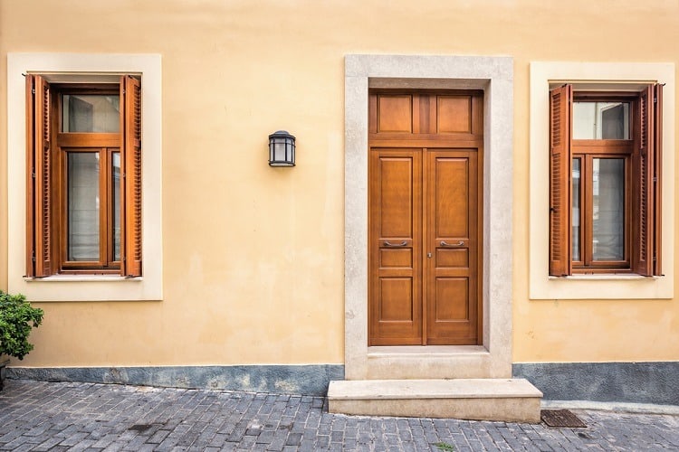 brown stucco exterior window trim with wooden shutters cream wall