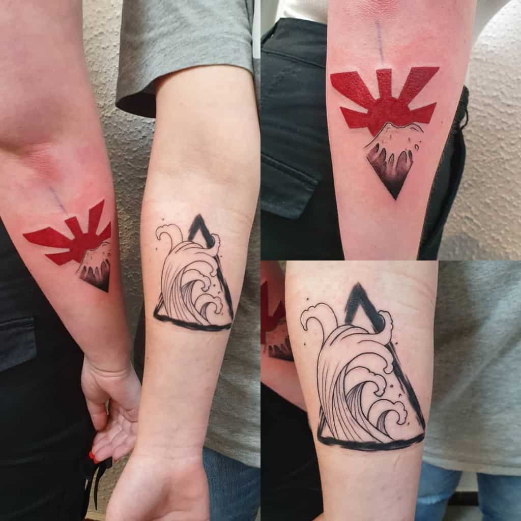 Matching sister tattoos featuring Mount Fuji with a rising sun in red on one arm, and a stylized wave within a triangle on the other