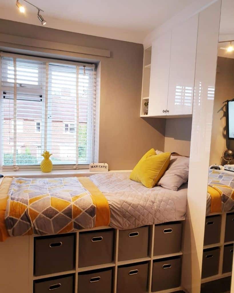 Single bed with storage cubes underneath and yellow accent bedding.
